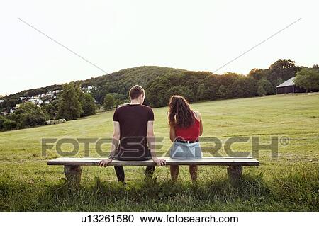 Stock Image - Couple sitting on bench overlooking hills, Wilhelminenberg, Vienna, Austria. Fotosearch