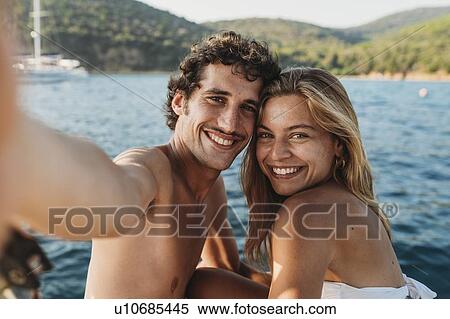 Couple taking selfie by seaside, Italy View Large Photo Image Stock Photography - Couple taking selfie by seaside, Italy. Fotosearch