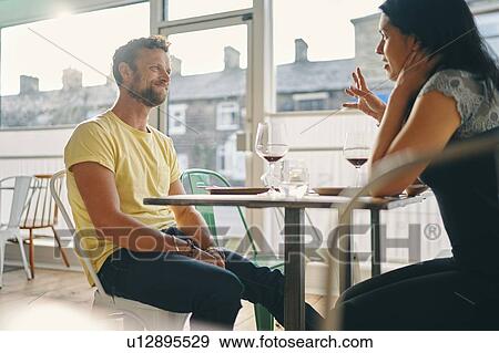 Stock Photo - Couple talking at mealtime in restaurant. Fotosearch