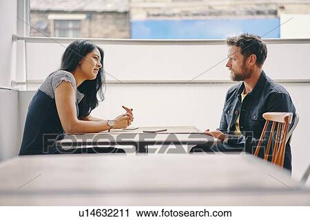 Stock Image - Couple talking in restaurant. Fotosearch