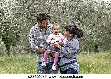 Couple with baby girl in garden, Florence, Italy View Large Photo Image Stock Photograph - Couple with baby girl in garden, Florence, Italy. Fotosearch