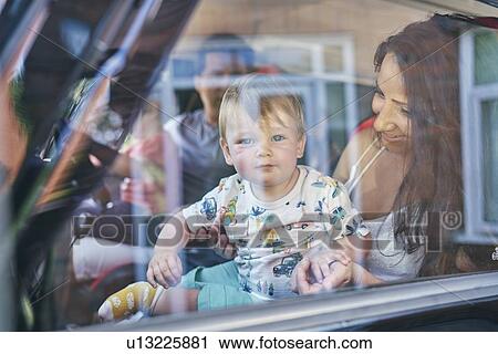 Couple with children sitting inside car View Large Photo Image Stock Image - Couple with children sitting inside car. Fotosearch