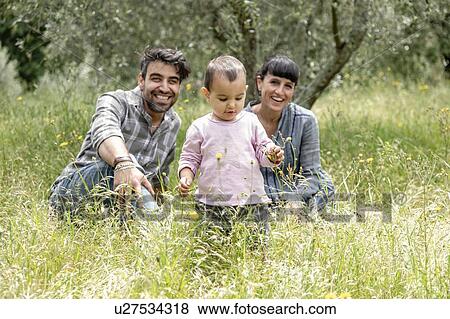 Stock Photo - Couple with toddler girl in garden, Florence, Italy. Fotosearch