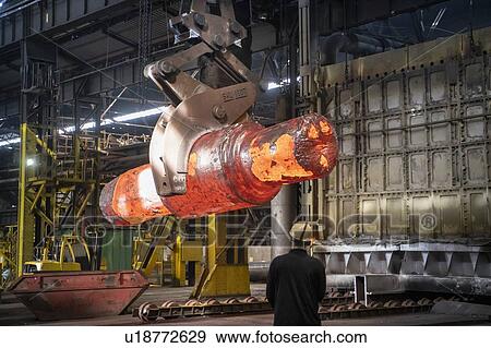 Stock Photo - Crane driver with red hot steel ingot in steelworks. Fotosearch