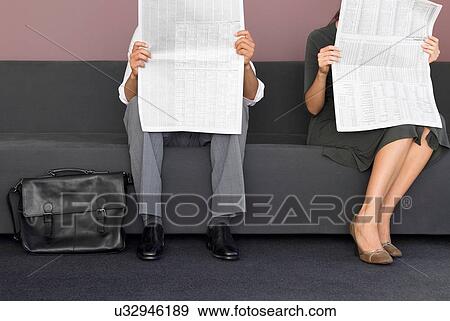 Cropped image of man and woman reading newspaper View Large Photo Image Stock Photo - Cropped image of man and woman reading newspaper. Fotosearch