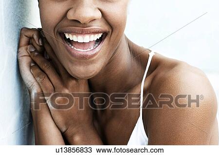 Stock Image - Cropped photo of attractive black woman wearing white top. Fotosearch