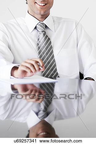 Cropped photo of businessman sitting at table in office View Large Photo Image Stock Image - Cropped photo of businessman sitting at table in office. Fotosearch