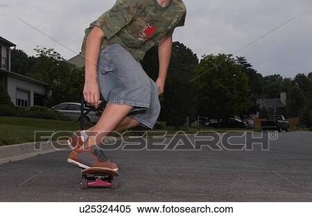 Cropped photo of kid riding skateboard View Large Photo Image Stock Photography - Cropped photo of kid riding skateboard. Fotosearch