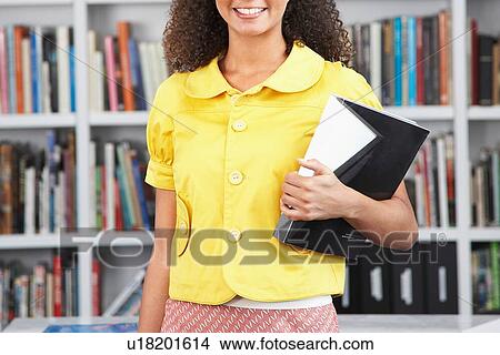 Picture - Cropped photo of student reading textbook from home office. Fotosearch