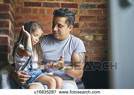 Daughter sitting on father's lap View Large Photo Image Stock Photo - Daughter sitting on father's lap. Fotosearch