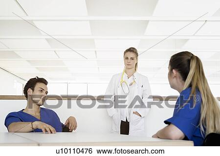 Doctor and nurses talking at corridor in hospital View Large Photo Image Stock Photograph - Doctor and nurses talking at corridor in hospital. Fotosearch