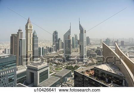 Stock Image - Dubai Clock Tower and Jumeirah Emirates Towers, Dubai, UAE. Fotosearch