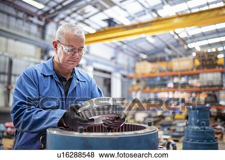 Engineer installing bearings into pump house in electrical engineering factory View Large Photo Image Stock Photo - Engineer installing bearings into pump house in electrical engineering factory. Fotosearch