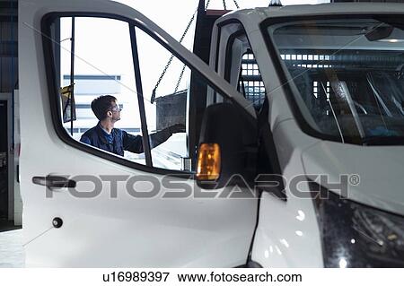 Stock Photo - Engineer loading parts into truck in electrical engineering factory. Fotosearch
