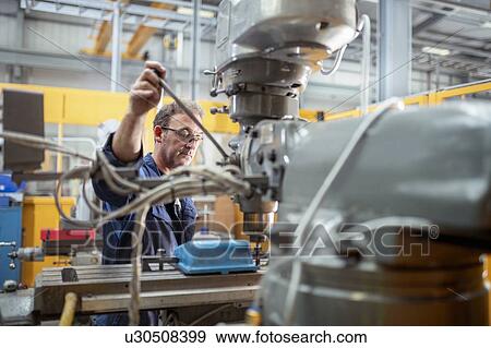 Engineer operating lathe in electrical engineering factory View Large Photo Image Stock Photo - Engineer operating lathe in electrical engineering factory. Fotosearch