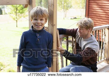 Father and son building treehouse together in garden View Large Photo Image Stock Image - Father and son building treehouse together in garden. Fotosearch