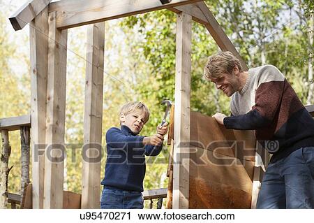 Father and son building treehouse together in garden View Large Photo Image Stock Image - Father and son building treehouse together in garden. Fotosearch