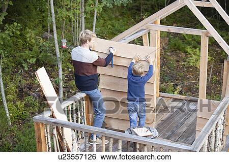 Father and son building treehouse together in garden View Large Photo Image Stock Photograph - Father and son building treehouse together in garden. Fotosearch