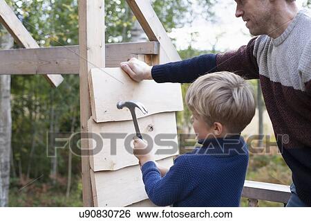 Father and son building treehouse together in garden View Large Photo Image Stock Photograph - Father and son building treehouse together in garden. Fotosearch