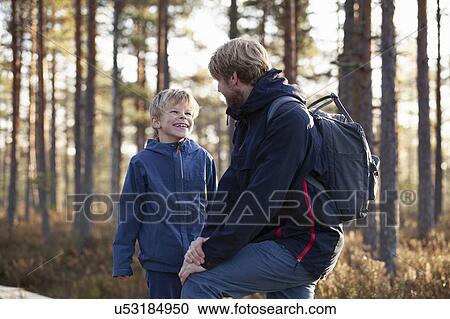 Stock Image - Father and son talking in forest, Finland. Fotosearch