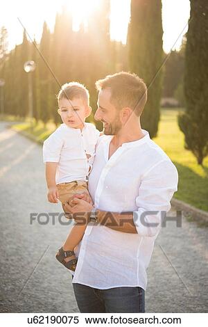 Father carrying son in park View Large Photo Image Stock Photography - Father carrying son in park. Fotosearch