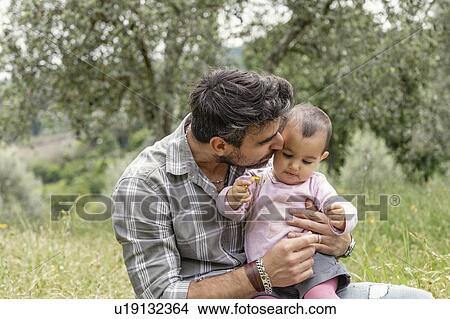 Picture - Father kissing baby girl in garden, Florence, Italy. Fotosearch