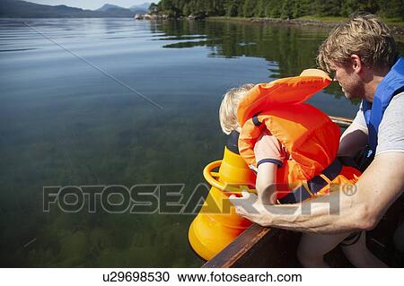 Father supporting son looking through telescope into lake on boat, Finland View Large Photo Image Stock Image - Father supporting son looking through telescope into lake on boat, Finland. Fotosearch