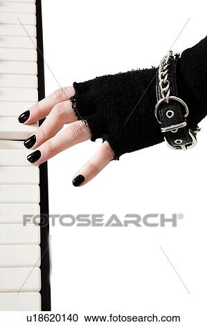 Stock Image - Female goth band playing keyboard piano. Fotosearch