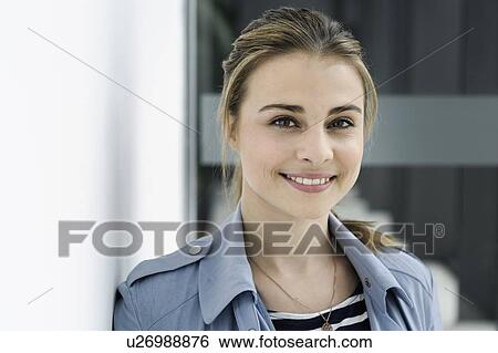 Female student leaning against white wall in office building View Large Photo Image Stock Photograph - Female student leaning against white wall in office building. Fotosearch