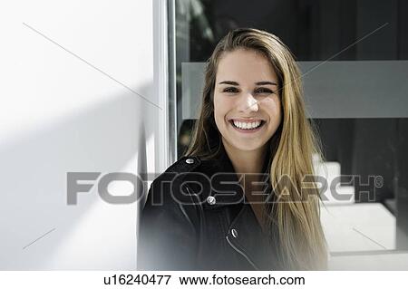 Stock Photo - Female student taking break at corridor in campus. Fotosearch