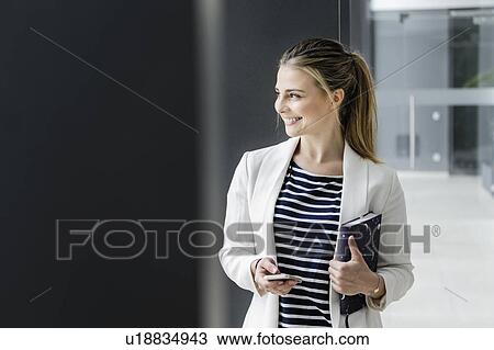 Female student with notebook at corridor of office building View Large Photo Image Stock Image - Female student with notebook at corridor of office building. Fotosearch