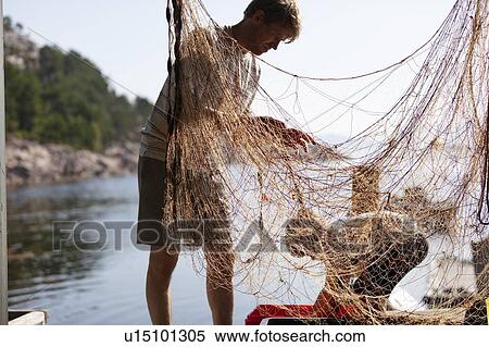 Stock Photography - Fisherman and boy disentangling fishing net. Fotosearch