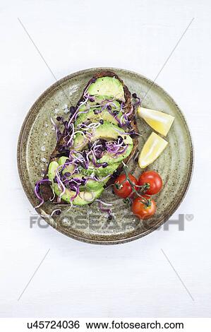 Stock Photograph - Fresh cut avocado on toasted bread. Fotosearch