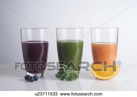 Stock Image - Fresh juices made of berries, carrots and kale. Fotosearch
