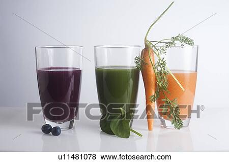 Stock Photo - Fresh juices made of berries, carrots and green leaves. Fotosearch