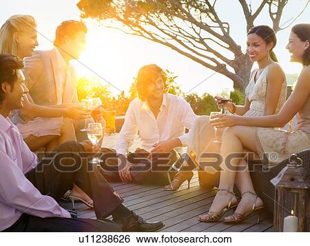 Stock Photograph - Friends Drinking together in balcony bar. Fotosearch