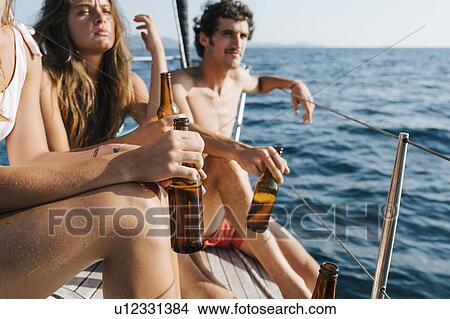 Friends enjoying beer on sailboat, Italy View Large Photo Image Picture - Friends enjoying beer on sailboat, Italy. Fotosearch