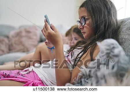 Stock Photo - Friends enjoying computer games on sofa. Fotosearch