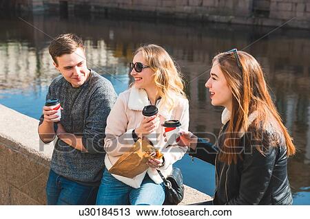 Friends having coffee by river View Large Photo Image Stock Image - Friends having coffee by river. Fotosearch