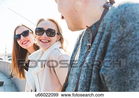 Stock Photo - Friends in city on sunny day. Fotosearch