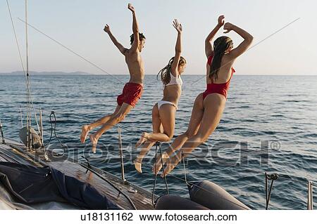 Friends jumping off sailboat into sea, Italy View Large Photo Image Stock Image - Friends jumping off sailboat into sea, Italy. Fotosearch