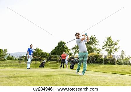 Friends playing golf on golf course View Large Photo Image Stock Image - Friends playing golf on golf course. Fotosearch