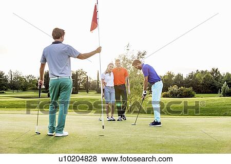 Friends playing golf on golf course View Large Photo Image Stock Photo - Friends playing golf on golf course. Fotosearch
