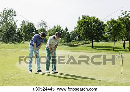Friends playing golf on golf course View Large Photo Image Stock Photography - Friends playing golf on golf course. Fotosearch