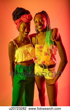 Friends posing against orange background View Large Photo Image Stock Image - Friends posing against orange background. Fotosearch