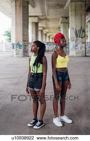 Stock Image - Friends posing back to back in city. Fotosearch