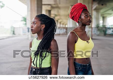 Friends posing back to back in city View Large Photo Image Stock Photograph - Friends posing back to back in city. Fotosearch