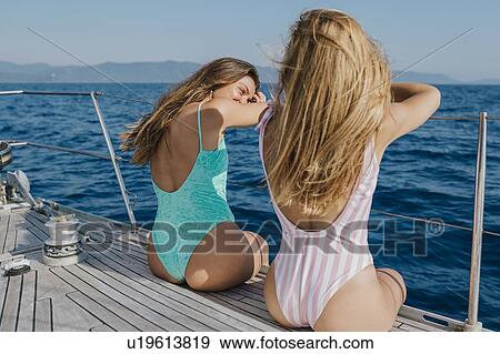Friends relaxing on deck edge of sailboat, Italy View Large Photo Image Stock Photo - Friends relaxing on deck edge of sailboat, Italy. Fotosearch