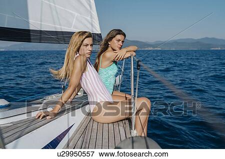 Friends relaxing on deck edge of sailboat, Italy View Large Photo Image Stock Photo - Friends relaxing on deck edge of sailboat, Italy. Fotosearch