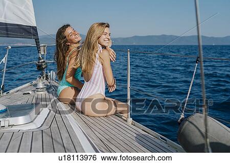 Friends relaxing on deck edge of sailboat, Italy View Large Photo Image Stock Photograph - Friends relaxing on deck edge of sailboat, Italy. Fotosearch